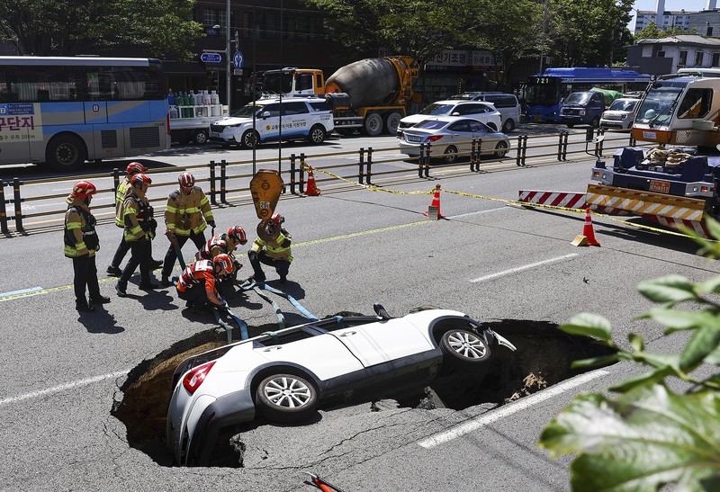 A vehicle that fell into a sinkhole is seen on a street in Seoul, South Korea, Thursday, Aug. 29, 2024. (Seo Dae-yeon/Yonhap via AP)