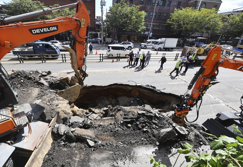 A vehicle that fell into a sinkhole is seen on a street in Seoul, South Korea, Thursday, Aug. 29, 2024. (Seo Dae-yeon/Yonhap via AP)