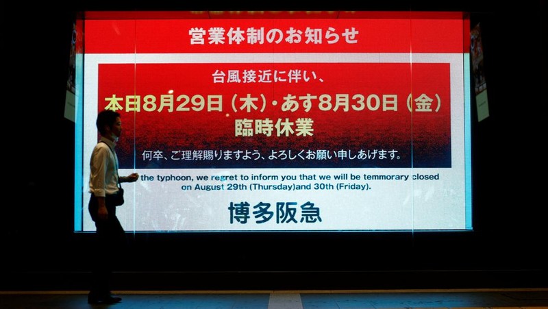 Petugas polisi berdiri selama operasi penyelamatan di daerah yang terkena dampak banjir akibat hujan lebat yang disebabkan oleh Topan Shanshan di Gamagori, prefektur Aichi, Jepang, 29 Agustus 2024, dalam foto yang diambil oleh Kyodo. (Mandatory credit Kyodo/via REUTERS)