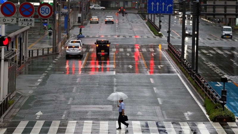 Petugas polisi berdiri selama operasi penyelamatan di daerah yang terkena dampak banjir akibat hujan lebat yang disebabkan oleh Topan Shanshan di Gamagori, prefektur Aichi, Jepang, 29 Agustus 2024, dalam foto yang diambil oleh Kyodo. (Mandatory credit Kyodo/via REUTERS)