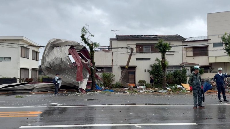 Petugas polisi berdiri selama operasi penyelamatan di daerah yang terkena dampak banjir akibat hujan lebat yang disebabkan oleh Topan Shanshan di Gamagori, prefektur Aichi, Jepang, 29 Agustus 2024, dalam foto yang diambil oleh Kyodo. (Mandatory credit Kyodo/via REUTERS)