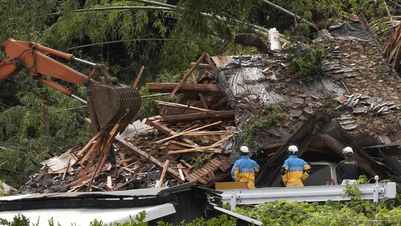 Petugas polisi berdiri selama operasi penyelamatan di daerah yang terkena dampak banjir akibat hujan lebat yang disebabkan oleh Topan Shanshan di Gamagori, prefektur Aichi, Jepang, 29 Agustus 2024, dalam foto yang diambil oleh Kyodo. (Mandatory credit Kyodo/via REUTERS)