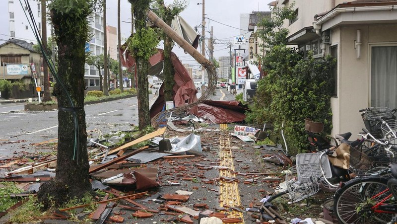 Petugas polisi berdiri selama operasi penyelamatan di daerah yang terkena dampak banjir akibat hujan lebat yang disebabkan oleh Topan Shanshan di Gamagori, prefektur Aichi, Jepang, 29 Agustus 2024, dalam foto yang diambil oleh Kyodo. (Mandatory credit Kyodo/via REUTERS)