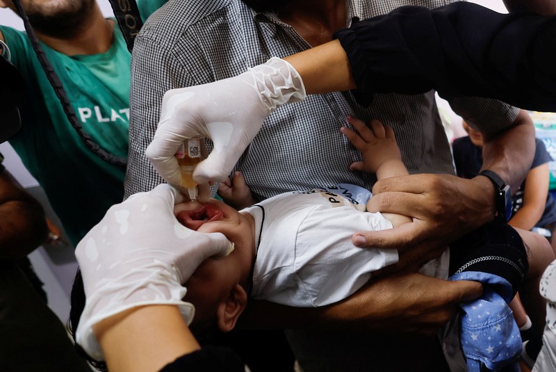 Seorang pria Palestina menggendong seorang anak, saat anak tersebut divaksinasi polio, di tengah konflik Israel-Hamas, di rumah sakit Nasser di Khan Younis di Jalur Gaza selatan, 31 Agustus 2024. Seorang pria Palestina menggendong seorang anak, saat anak tersebut divaksinasi polio, di tengah konflik Israel-Hamas, di rumah sakit Nasser di Khan Younis di Jalur Gaza selatan, 31 Agustus 2024. (REUTERS/Mohammed Salem)