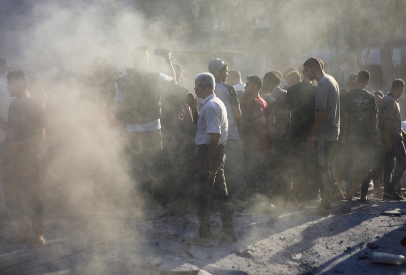 Warga Palestina berjalan di lokasi sekolah, yang menampung orang-orang terlantar, setelah terkena serangan Israel, di tengah konflik Israel-Hamas, di Kota Gaza, 1 September 2024. (REUTERS/Dawoud Abu Alkas)