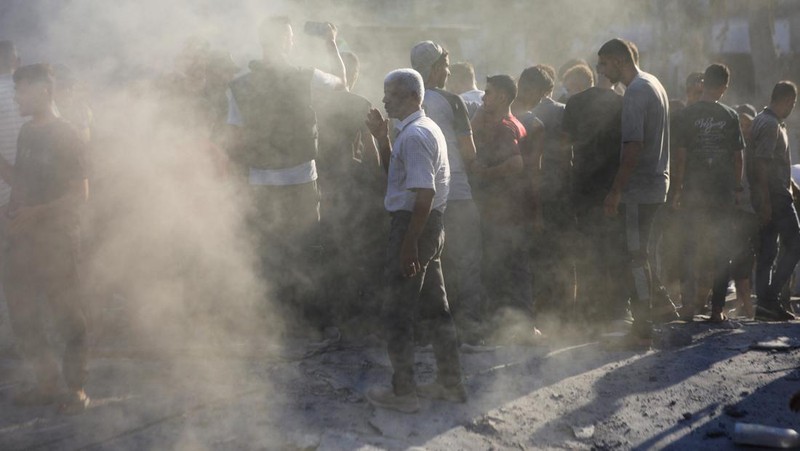Warga Palestina berjalan di lokasi sekolah, yang menampung orang-orang terlantar, setelah terkena serangan Israel, di tengah konflik Israel-Hamas, di Kota Gaza, 1 September 2024. (REUTERS/Dawoud Abu Alkas)
