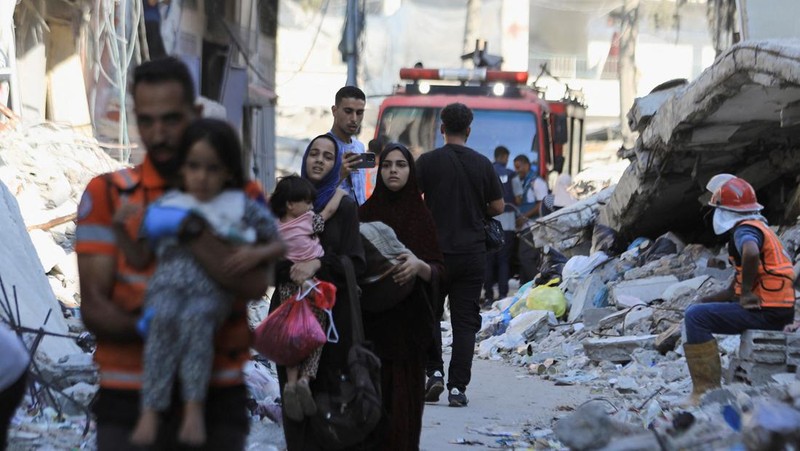 Warga Palestina berjalan di lokasi sekolah, yang menampung orang-orang terlantar, setelah terkena serangan Israel, di tengah konflik Israel-Hamas, di Kota Gaza, 1 September 2024. (REUTERS/Dawoud Abu Alkas)