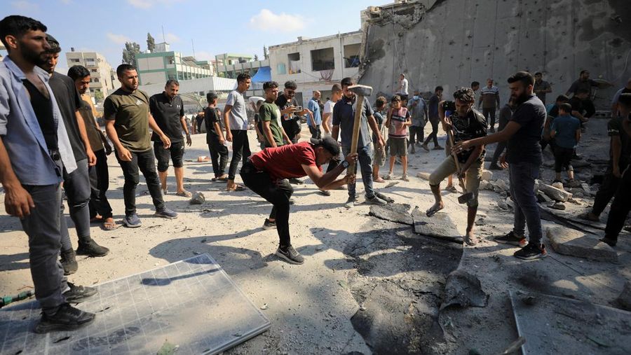 Warga Palestina berjalan di lokasi sekolah, yang menampung orang-orang terlantar, setelah terkena serangan Israel, di tengah konflik Israel-Hamas, di Kota Gaza, 1 September 2024. (REUTERS/Dawoud Abu Alkas)