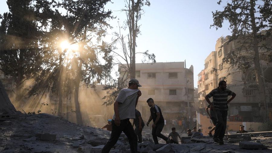 Warga Palestina berjalan di lokasi sekolah, yang menampung orang-orang terlantar, setelah terkena serangan Israel, di tengah konflik Israel-Hamas, di Kota Gaza, 1 September 2024. (REUTERS/Dawoud Abu Alkas)