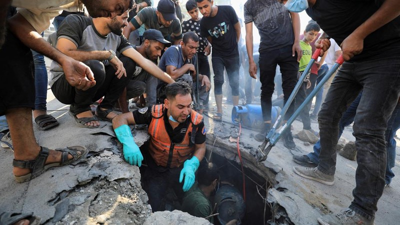 Warga Palestina berjalan di lokasi sekolah, yang menampung orang-orang terlantar, setelah terkena serangan Israel, di tengah konflik Israel-Hamas, di Kota Gaza, 1 September 2024. (REUTERS/Dawoud Abu Alkas)