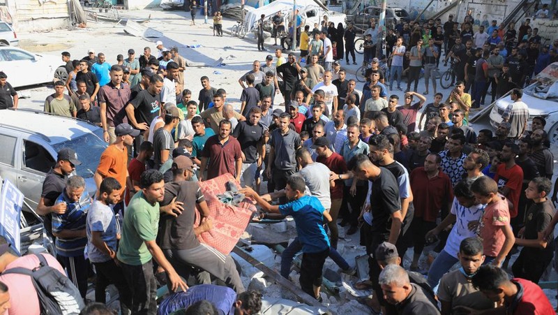 Warga Palestina berjalan di lokasi sekolah, yang menampung orang-orang terlantar, setelah terkena serangan Israel, di tengah konflik Israel-Hamas, di Kota Gaza, 1 September 2024. (REUTERS/Dawoud Abu Alkas)