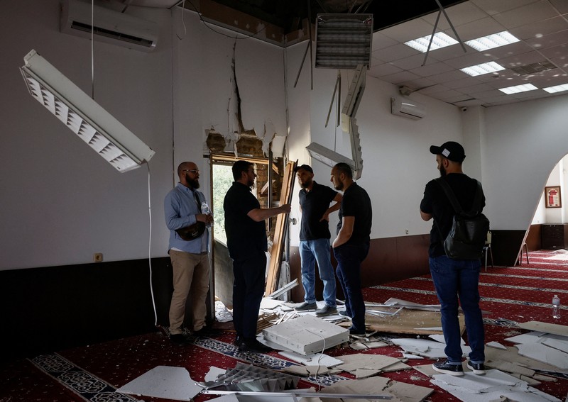 Anggota komunitas Muslim memeriksa kerusakan di masjid Asosiasi Muslim Ukraina, akibat serangan rudal Rusia yang menghancurkan bangunan di sebelahnya, di tengah konflik Rusia-Ukraina, di Kyiv, Ukraina, 2 September 2024. (REUTERS/Thomas Peter)