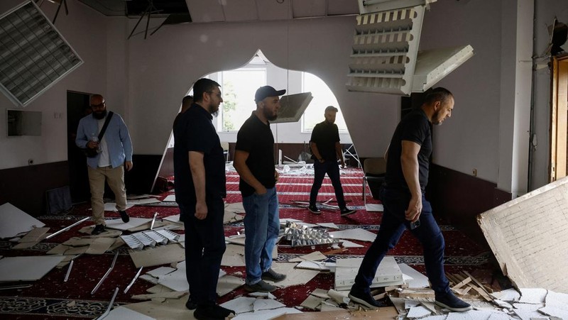 Anggota komunitas Muslim memeriksa kerusakan di masjid Asosiasi Muslim Ukraina, akibat serangan rudal Rusia yang menghancurkan bangunan di sebelahnya, di tengah konflik Rusia-Ukraina, di Kyiv, Ukraina, 2 September 2024. (REUTERS/Thomas Peter)