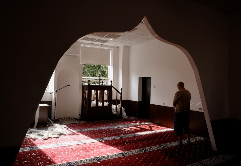 Anggota komunitas Muslim memeriksa kerusakan di masjid Asosiasi Muslim Ukraina, akibat serangan rudal Rusia yang menghancurkan bangunan di sebelahnya, di tengah konflik Rusia-Ukraina, di Kyiv, Ukraina, 2 September 2024. (REUTERS/Thomas Peter)