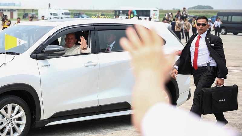 Paus Fransiskus di kursi rodanya, melambaikan tangan saat tiba selama upacara penyambutan resmi di Bandara Internasional Soekarno-Hatta di Tangerang di pinggiran Jakarta, Indonesia, Selasa, 3 September 2024. (AP Photo/Achmad Ibrahim)