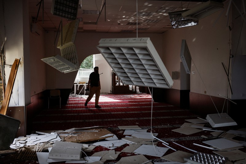 Anggota komunitas Muslim memeriksa kerusakan di masjid Asosiasi Muslim Ukraina, akibat serangan rudal Rusia yang menghancurkan bangunan di sebelahnya, di tengah konflik Rusia-Ukraina, di Kyiv, Ukraina, 2 September 2024. (REUTERS/Thomas Peter)