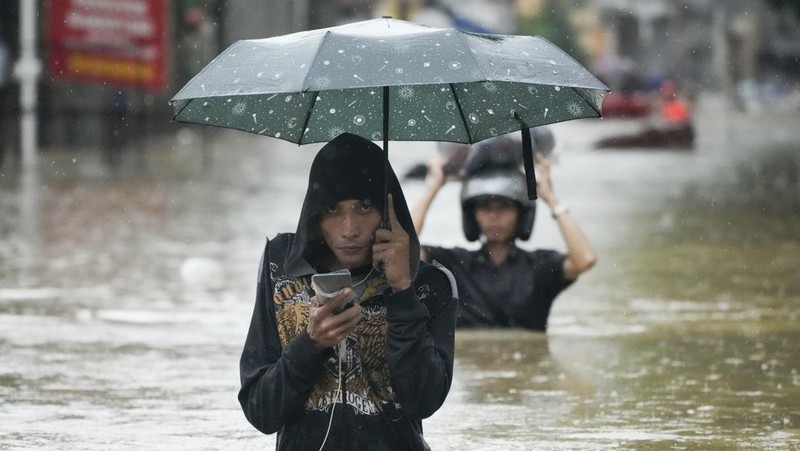 Seorang warga mengendarai kulkas tua melewati jalan yang banjir akibat hujan lebat akibat Badai Tropis Yagi, yang secara lokal disebut Enteng, pada hari Senin, 2 September 2024, di Cainta, provinsi Rizal, Filipina. (AP Photo/Aaron Favila)