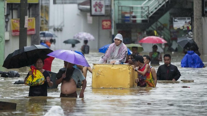 Seorang warga mengendarai kulkas tua melewati jalan yang banjir akibat hujan lebat akibat Badai Tropis Yagi, yang secara lokal disebut Enteng, pada hari Senin, 2 September 2024, di Cainta, provinsi Rizal, Filipina. (AP Photo/Aaron Favila)