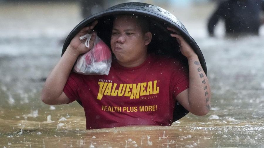 Seorang warga mengendarai kulkas tua melewati jalan yang banjir akibat hujan lebat akibat Badai Tropis Yagi, yang secara lokal disebut Enteng, pada hari Senin, 2 September 2024, di Cainta, provinsi Rizal, Filipina. (AP Photo/Aaron Favila)