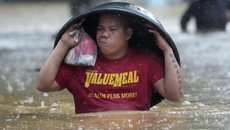 Seorang warga mengendarai kulkas tua melewati jalan yang banjir akibat hujan lebat akibat Badai Tropis Yagi, yang secara lokal disebut Enteng, pada hari Senin, 2 September 2024, di Cainta, provinsi Rizal, Filipina. (AP Photo/Aaron Favila)