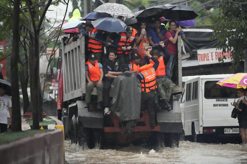 Seorang warga mengendarai kulkas tua melewati jalan yang banjir akibat hujan lebat akibat Badai Tropis Yagi, yang secara lokal disebut Enteng, pada hari Senin, 2 September 2024, di Cainta, provinsi Rizal, Filipina. (AP Photo/Aaron Favila)