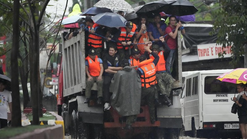 Seorang warga mengendarai kulkas tua melewati jalan yang banjir akibat hujan lebat akibat Badai Tropis Yagi, yang secara lokal disebut Enteng, pada hari Senin, 2 September 2024, di Cainta, provinsi Rizal, Filipina. (AP Photo/Aaron Favila)