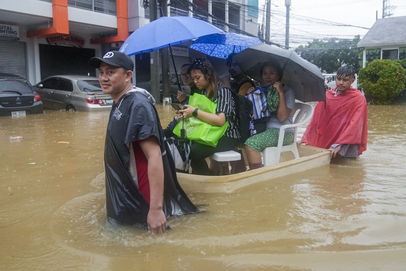 Seorang warga mengendarai kulkas tua melewati jalan yang banjir akibat hujan lebat akibat Badai Tropis Yagi, yang secara lokal disebut Enteng, pada hari Senin, 2 September 2024, di Cainta, provinsi Rizal, Filipina. (AP Photo/Aaron Favila)