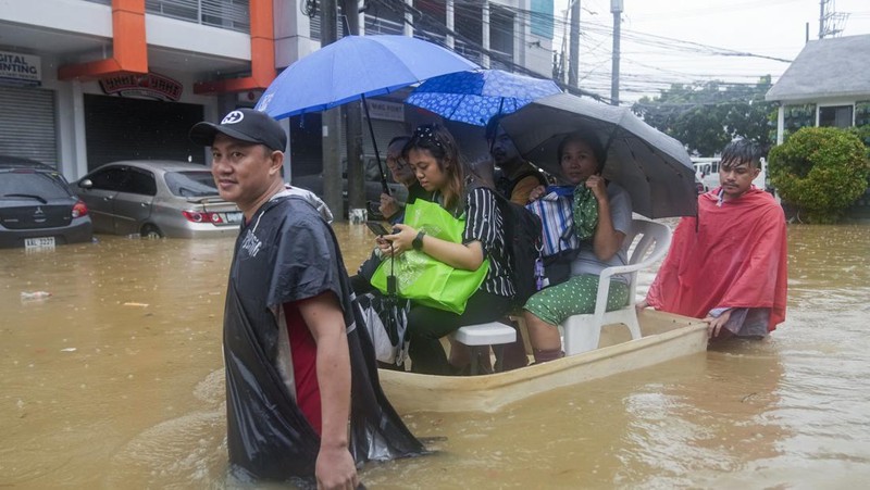 Seorang warga mengendarai kulkas tua melewati jalan yang banjir akibat hujan lebat akibat Badai Tropis Yagi, yang secara lokal disebut Enteng, pada hari Senin, 2 September 2024, di Cainta, provinsi Rizal, Filipina. (AP Photo/Aaron Favila)