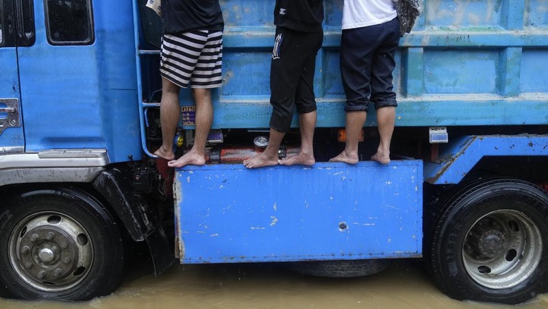 Seorang warga mengendarai kulkas tua melewati jalan yang banjir akibat hujan lebat akibat Badai Tropis Yagi, yang secara lokal disebut Enteng, pada hari Senin, 2 September 2024, di Cainta, provinsi Rizal, Filipina. (AP Photo/Aaron Favila)