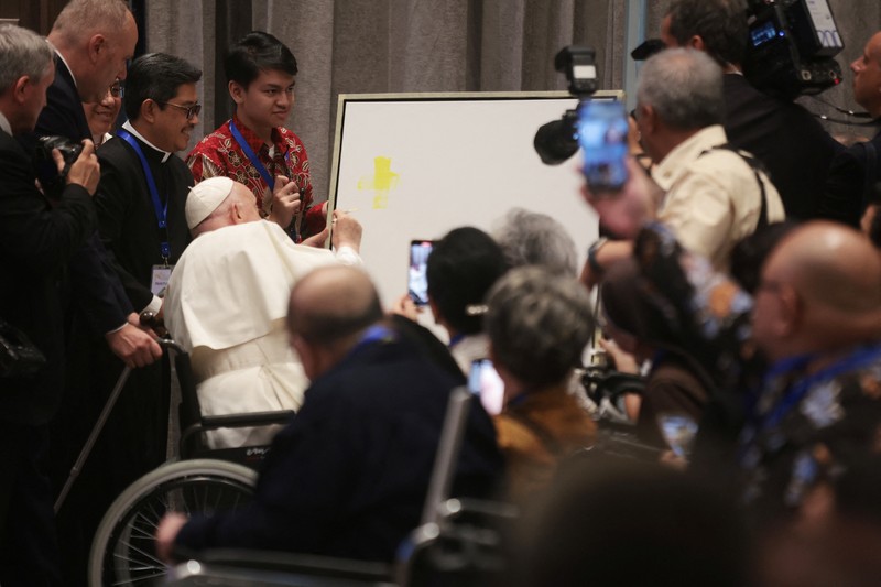 POPE-ASIA/INDONESIA Pope Francis makes a brush stroke on a canvas during a meeting with beneficiaries from charitable organizations at the Indonesian Bishops' Conference Headquarters in Jakarta, Indonesia, 05 September 2024. ADI WEDA/Pool via REUTERS