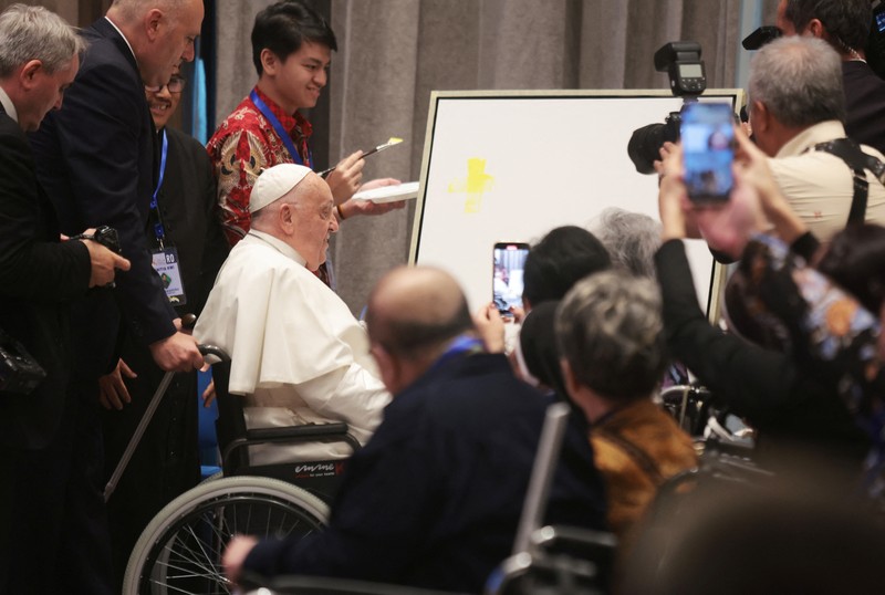 Pope Francis makes a brush stroke on a canvas during a meeting with beneficiaries from charitable organizations at the Indonesian Bishops' Conference Headquarters in Jakarta, Indonesia, 05 September 2024. ADI WEDA/Pool via REUTERS