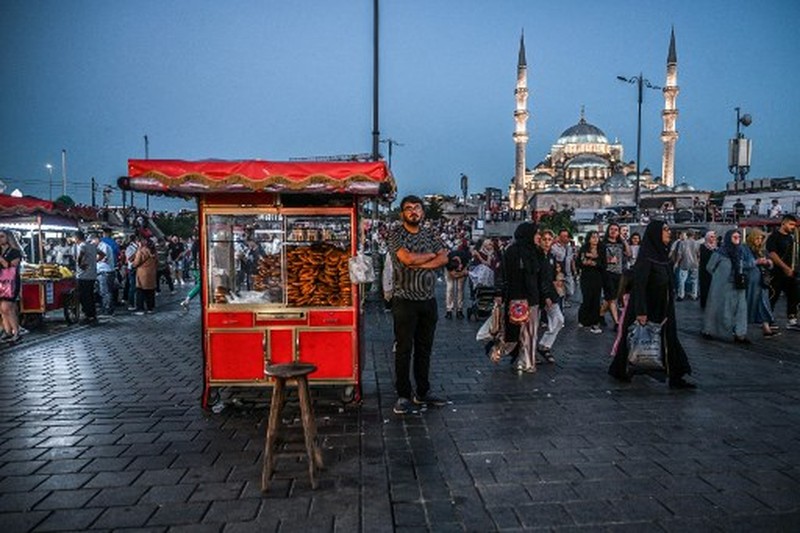 TURKEY-ECONOMY-INFLATION A street vendor sells corn in the Eminonu district of Istanbul on August 29, 2024. In Istanbul, street vendors, popular figures inherited from the Ottoman Empire, are brooding over the loss of a large part of their Turkish clientele, stunned by inflation. (Photo by Ozan KOSE / AFP)