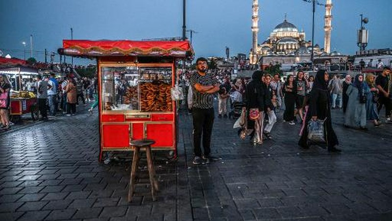 A street vendor sells corn in the Eminonu district of Istanbul on August 29, 2024. In Istanbul, street vendors, popular figures inherited from the Ottoman Empire, are brooding over the loss of a large part of their Turkish clientele, stunned by inflation. (Photo by Ozan KOSE / AFP)