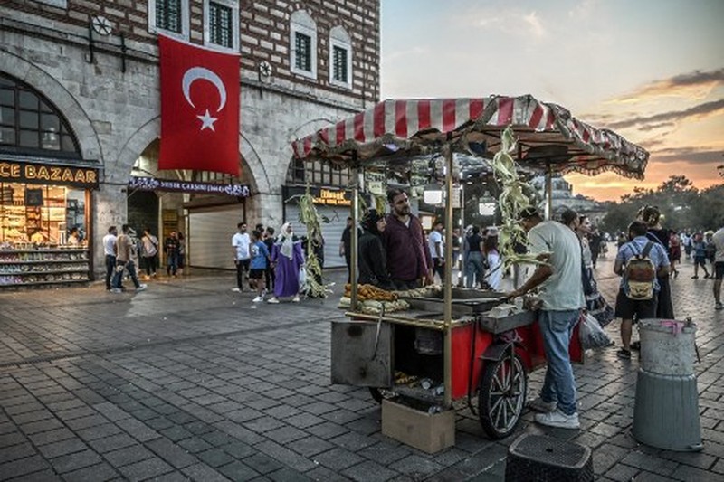TURKEY-ECONOMY-INFLATION A street vendor sells corn in the Eminonu district of Istanbul on August 29, 2024. In Istanbul, street vendors, popular figures inherited from the Ottoman Empire, are brooding over the loss of a large part of their Turkish clientele, stunned by inflation. (Photo by Ozan KOSE / AFP)