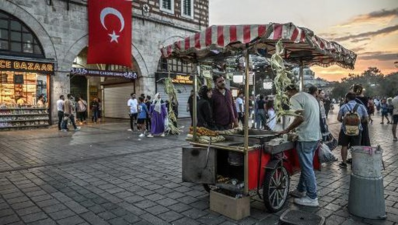 A street vendor sells corn in the Eminonu district of Istanbul on August 29, 2024. In Istanbul, street vendors, popular figures inherited from the Ottoman Empire, are brooding over the loss of a large part of their Turkish clientele, stunned by inflation. (Photo by Ozan KOSE / AFP)