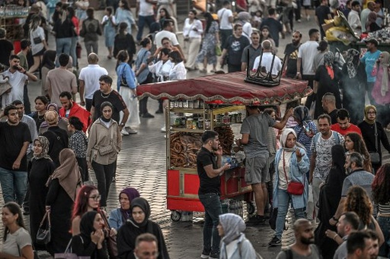 A street vendor sells corn in the Eminonu district of Istanbul on August 29, 2024. In Istanbul, street vendors, popular figures inherited from the Ottoman Empire, are brooding over the loss of a large part of their Turkish clientele, stunned by inflation. (Photo by Ozan KOSE / AFP)