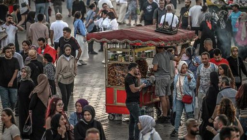 A street vendor sells corn in the Eminonu district of Istanbul on August 29, 2024. In Istanbul, street vendors, popular figures inherited from the Ottoman Empire, are brooding over the loss of a large part of their Turkish clientele, stunned by inflation. (Photo by Ozan KOSE / AFP)