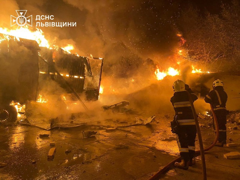 Api dan asap mengepul dari truk yang terbakar di lokasi fasilitas gudang yang terkena serangan pesawat tak berawak Rusia, di tengah serangan Rusia terhadap Ukraina, di desa Murovane, di luar Lviv, Ukraina, 6 September 2024. (Press service of the State Emergency Service of Ukraine/Handout via REUTERS)