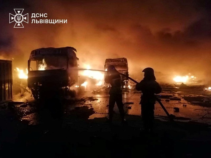 Api dan asap mengepul dari truk yang terbakar di lokasi fasilitas gudang yang terkena serangan pesawat tak berawak Rusia, di tengah serangan Rusia terhadap Ukraina, di desa Murovane, di luar Lviv, Ukraina, 6 September 2024. (Press service of the State Emergency Service of Ukraine/Handout via REUTERS)