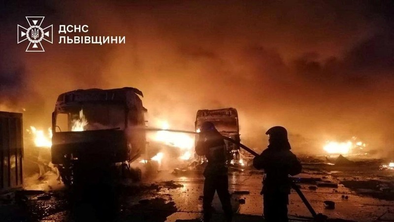 Api dan asap mengepul dari truk yang terbakar di lokasi fasilitas gudang yang terkena serangan pesawat tak berawak Rusia, di tengah serangan Rusia terhadap Ukraina, di desa Murovane, di luar Lviv, Ukraina, 6 September 2024. (Press service of the State Emergency Service of Ukraine/Handout via REUTERS)