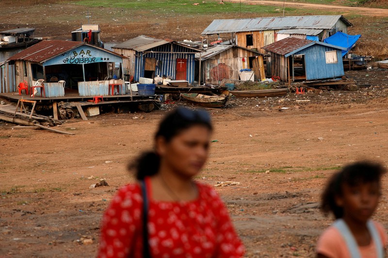 Orang-orang melihat di dekat rumah-rumah terapung yang terdampar akibat kekeringan yang melanda Rio Negro, anak sungai kiri terbesar dari Sungai Amazon, di distrik Cacau Pirera di Iranduba, negara bagian Amazonas, Brasil, 2 September 2024. Orang-orang melihat di dekat rumah-rumah terapung yang terdampar akibat kekeringan yang melanda Rio Negro, anak sungai kiri terbesar dari Sungai Amazon, di distrik Cacau Pirera di Iranduba, negara bagian Amazonas, Brasil, 2 September 2024. (REUTERS/Bruno Kelly)