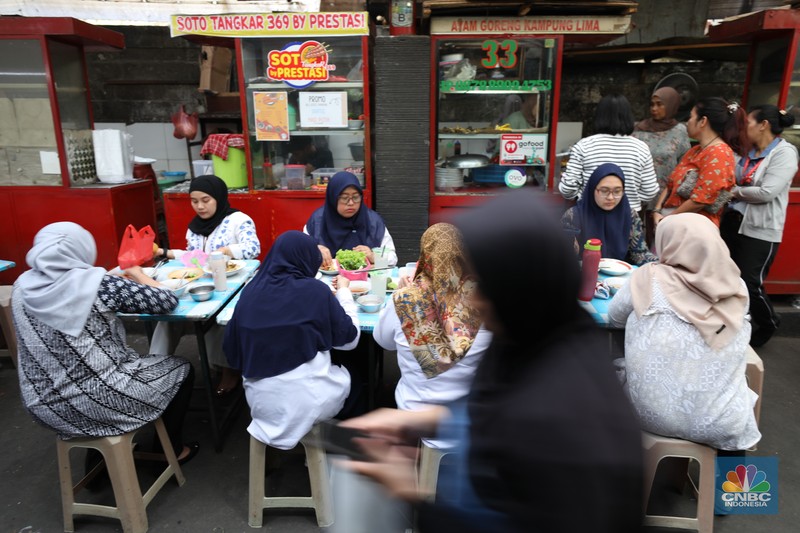 Sejumlah pekerja menyantap makan siang di pusat kuliner di kawasan Jakarta, Jumat (6/9/2024). (CNBC Indonesia/Tri Susilo)
