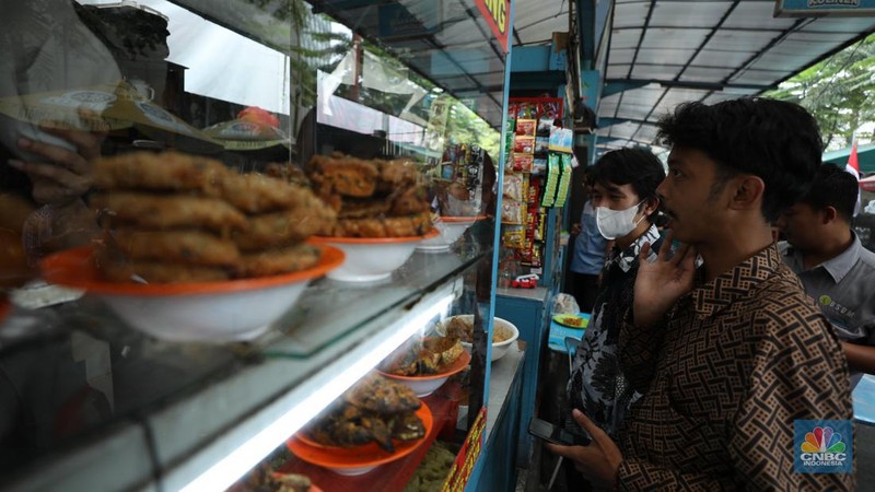 Sejumlah pekerja menyantap makan siang di pusat kuliner di kawasan Jakarta, Jumat (6/9/2024). (CNBC Indonesia/Tri Susilo)