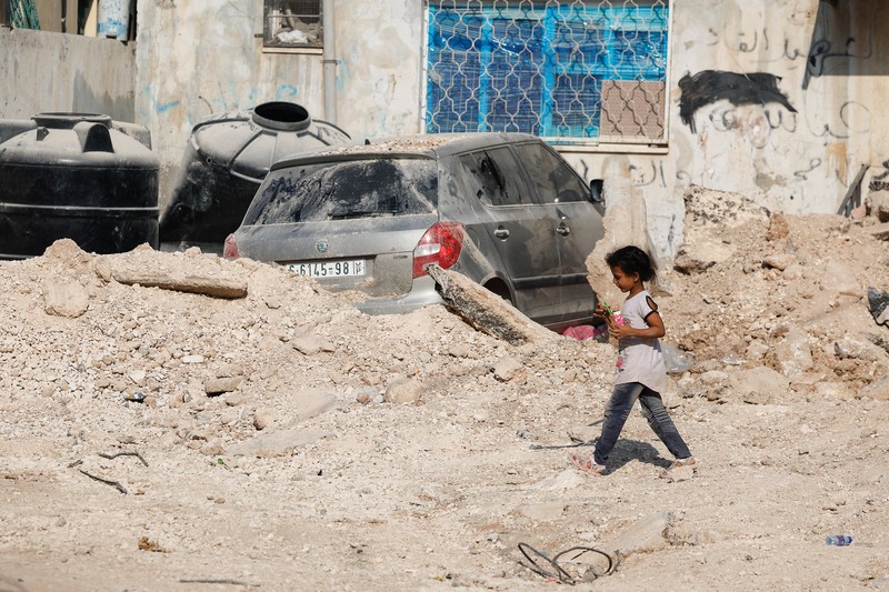 A Palestinian child walks along a damaged road, following a several day long Israeli-raid, in Jenin camp, in the Israeli-occupied West Bank, September 6, 2024. REUTERS/Raneen Sawafta
