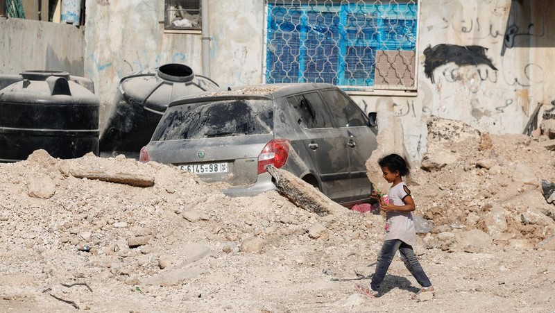 A Palestinian child walks along a damaged road, following a several day long Israeli-raid, in Jenin camp, in the Israeli-occupied West Bank, September 6, 2024. REUTERS/Raneen Sawafta