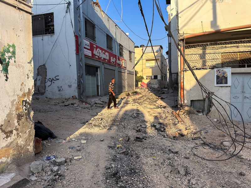 A Palestinian child walks along a damaged road, following a several day long Israeli-raid, in Jenin camp, in the Israeli-occupied West Bank, September 6, 2024. REUTERS/Raneen Sawafta