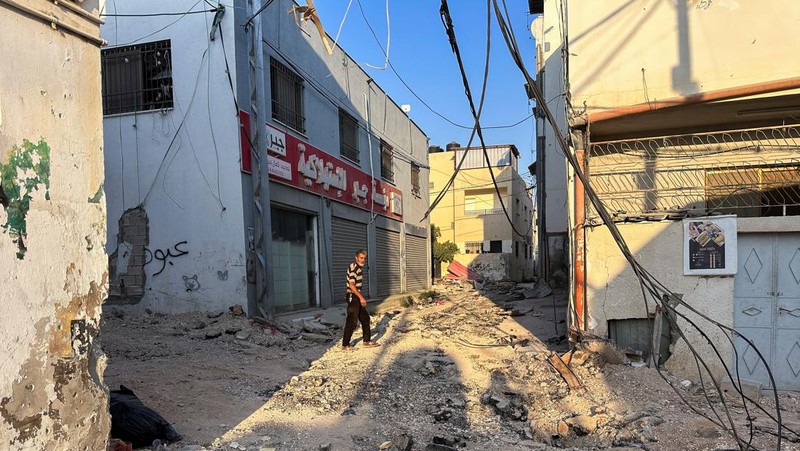 A Palestinian child walks along a damaged road, following a several day long Israeli-raid, in Jenin camp, in the Israeli-occupied West Bank, September 6, 2024. REUTERS/Raneen Sawafta