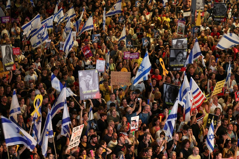 Para demonstran berkumpul di sekitar api unggun selama demonstrasi menentang pemerintahan Perdana Menteri Israel Benjamin Netanyahu dan menyerukan pembebasan sandera di Gaza, di tengah konflik Israel-Hamas, di Tel Aviv, Israel, 7 September 2024. (REUTERS/Florion Goga)