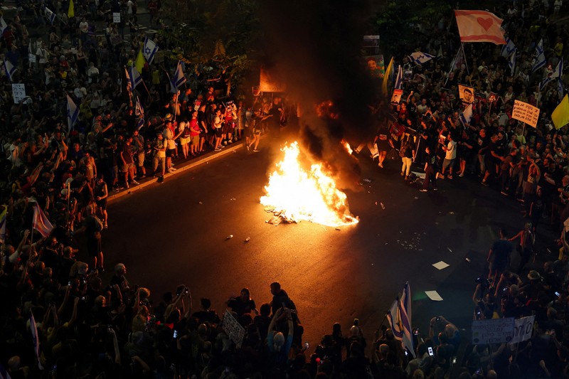 Para demonstran berkumpul di sekitar api unggun selama demonstrasi menentang pemerintahan Perdana Menteri Israel Benjamin Netanyahu dan menyerukan pembebasan sandera di Gaza, di tengah konflik Israel-Hamas, di Tel Aviv, Israel, 7 September 2024. Para demonstran berkumpul di sekitar api unggun selama demonstrasi menentang pemerintahan Perdana Menteri Israel Benjamin Netanyahu dan menyerukan pembebasan sandera di Gaza, di tengah konflik Israel-Hamas, di Tel Aviv, Israel, 7 September 2024. (REUTERS/Florion Goga)