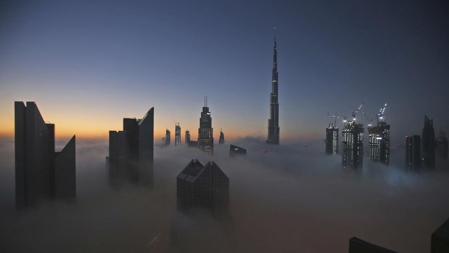 Matahari terbit di atas cakrawala kota dengan Burj Khalifa, gedung tertinggi di dunia, pada hari berkabut di Dubai, Uni Emirat Arab. (AP Photo/Kamran Jebreili/File Foto)